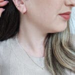 Imagem mostrando uma modelo usando brinco argola dourado da loja online Céu da Pele, junto com um piercing fake também da loja.